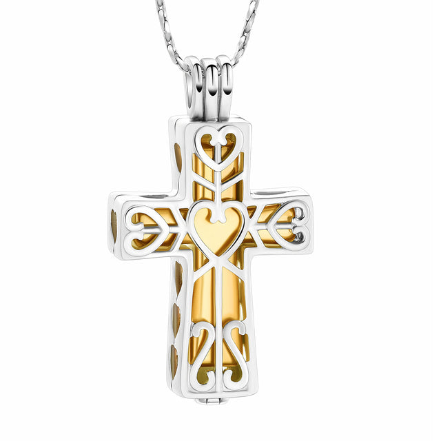 Cross urn pendant in silver and gold tone with heart design, crafted from stainless steel. Elegant cremation jewelry for ashes with satin cord and tool.