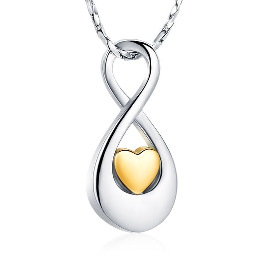 Infinity Gold Tone Heart Pendant in stainless steel featuring a gold-tone heart centerpiece. Includes ashes compartment, polishing cloth, and velvet bag.