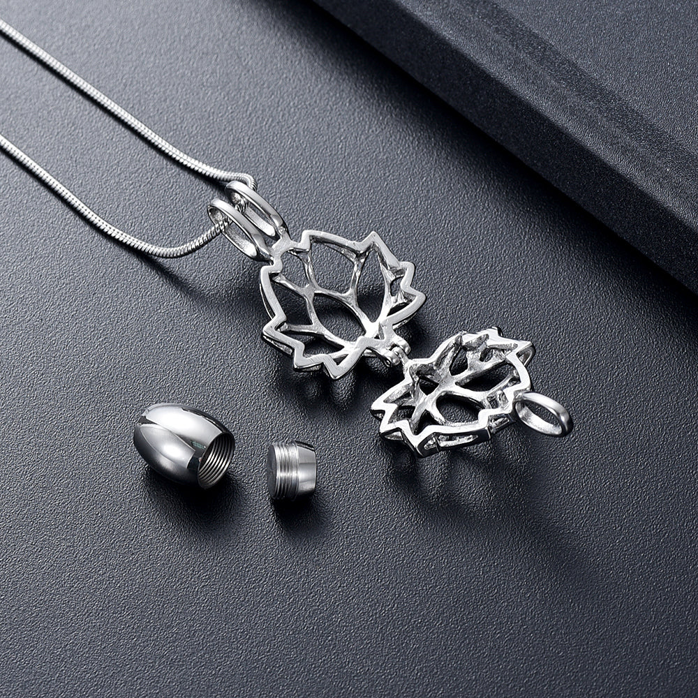 Lotus Urn Pendant Silver Tone - Keepsake Jewelry | Stainless Steel shown open with threaded urn capsule and accessories on dark background.